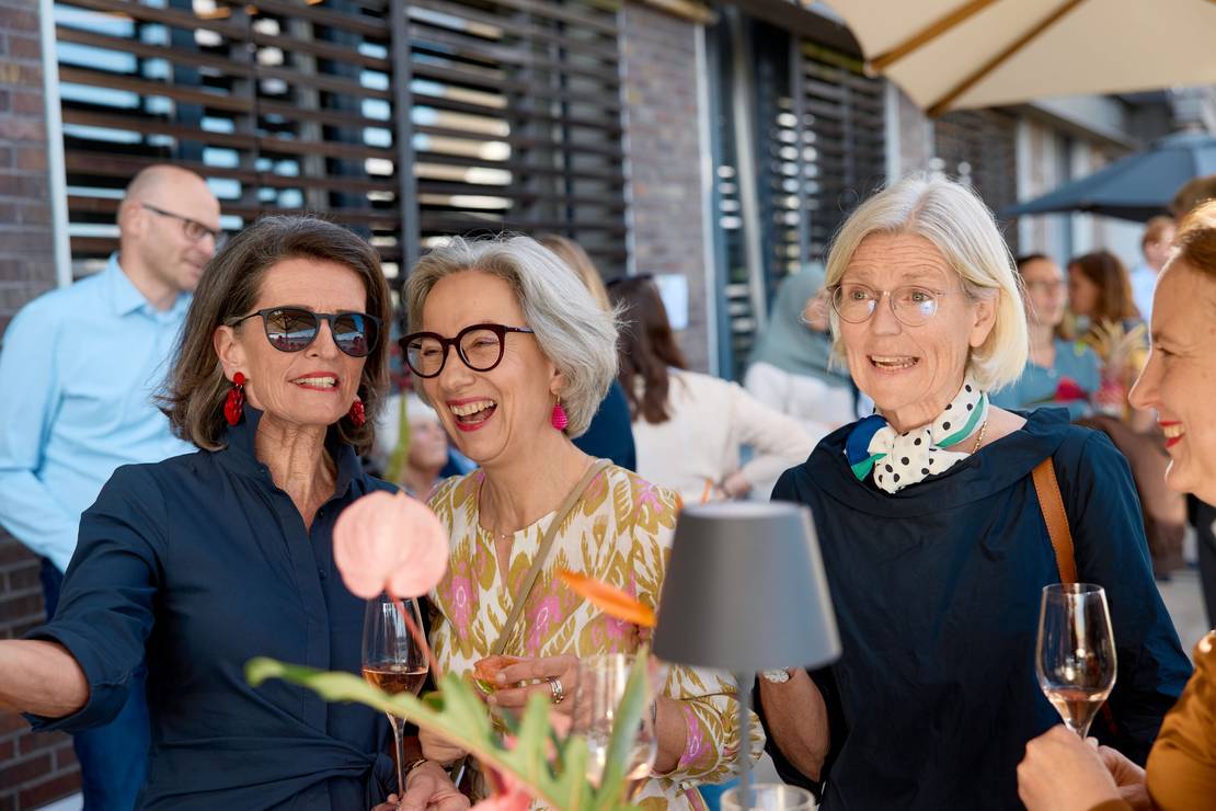 Foto von drei Frauen, die herzlich lachen.