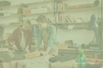 Foto von zwei jungen Leuten an einer Werkbank. Darauf der Text: Ausbildung.