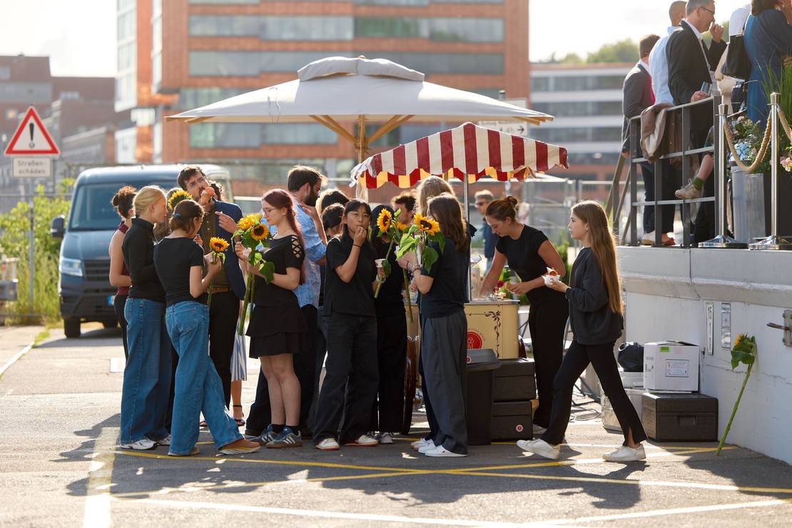 Eine Gruppe Kinder und Jugendlicher steht um den Eiswagen und isst Eis.