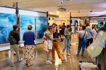 Ansicht der Ausstellung Mythos Heimat - eine Hinterfragung mit Gästen der Vernissage und Werken der Künstler:innen