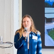 Porträt Alina Wilke mit Mikro beim Vortrag
