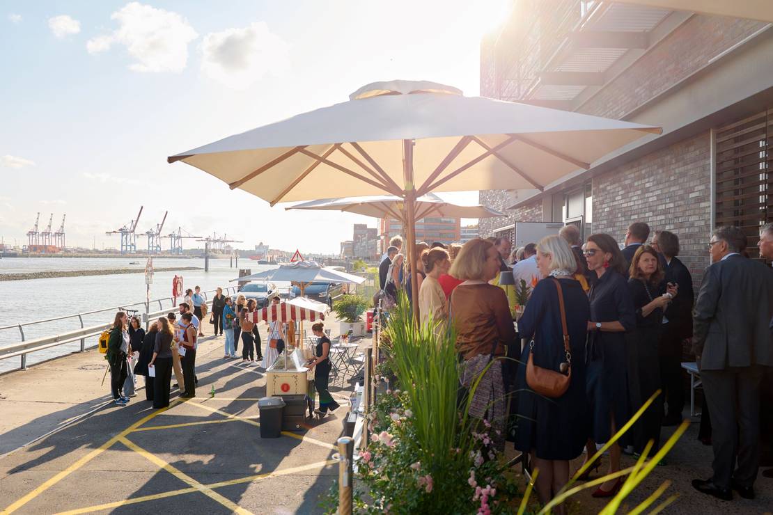 Impression von der Hafenkante. Menschen unterhalten sich. Das Licht fällt sehr schön auf die Szene.