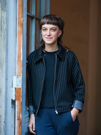 Porträt der Regisseurin Anja Kerschkewicz, an einer Wand lehnend